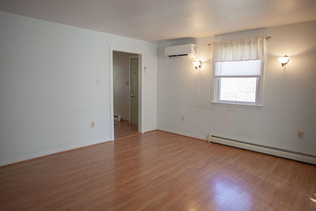 empty room featuring a baseboard heating unit, hardwood / wood-style floors, and a wall mounted air conditioner