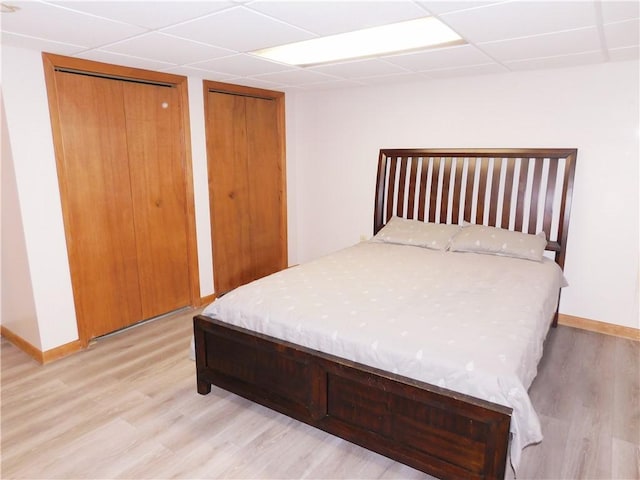 bedroom featuring two closets and light hardwood / wood-style flooring