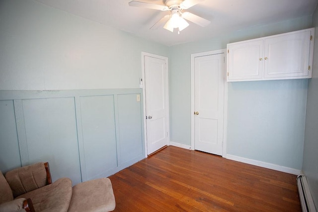 interior space with ceiling fan, dark hardwood / wood-style flooring, and a baseboard radiator