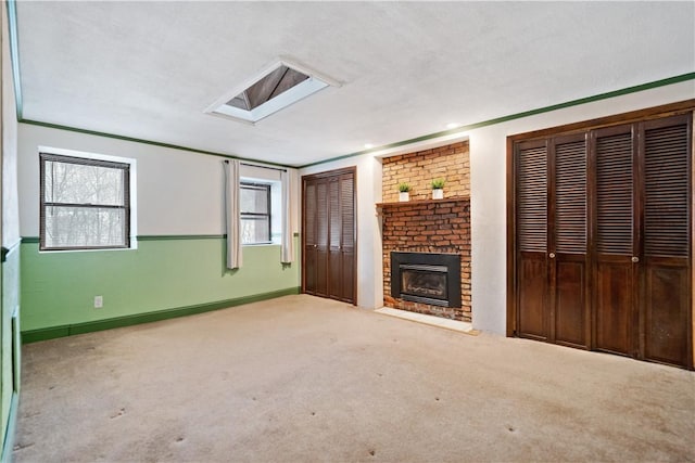 unfurnished living room featuring light carpet, a brick fireplace, baseboards, and a healthy amount of sunlight