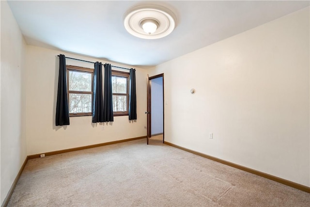 unfurnished room featuring light colored carpet and baseboards