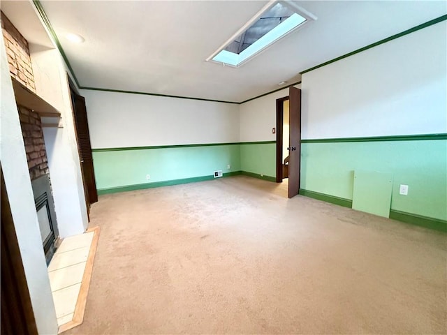 interior space featuring a brick fireplace, carpet, a skylight, and baseboards