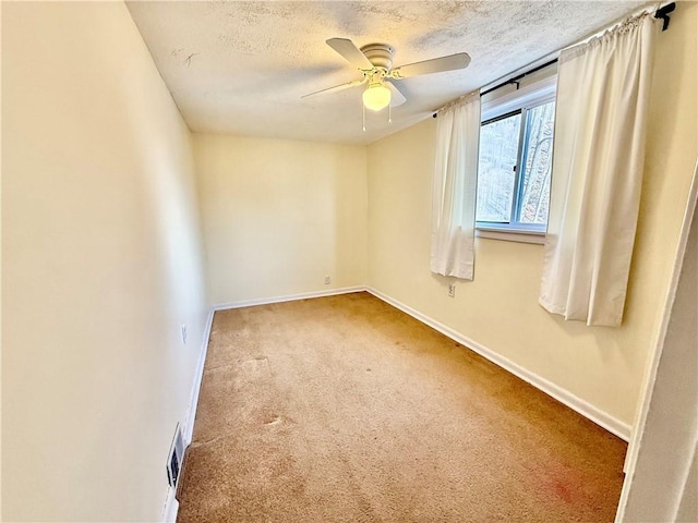 carpeted spare room featuring visible vents, a textured ceiling, and baseboards