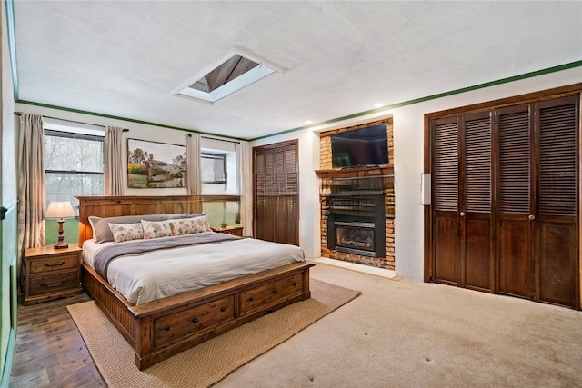 bedroom featuring a brick fireplace and two closets