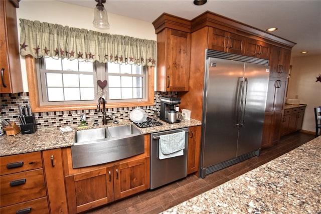 kitchen featuring light stone countertops, sink, stainless steel appliances, and tasteful backsplash