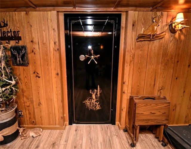 interior details featuring hardwood / wood-style floors and wood walls