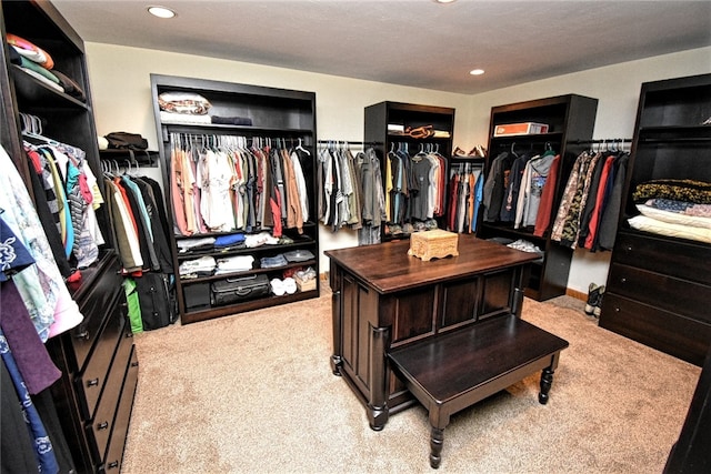 walk in closet with light carpet