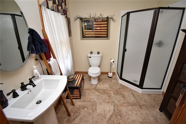 bathroom with toilet, walk in shower, and sink