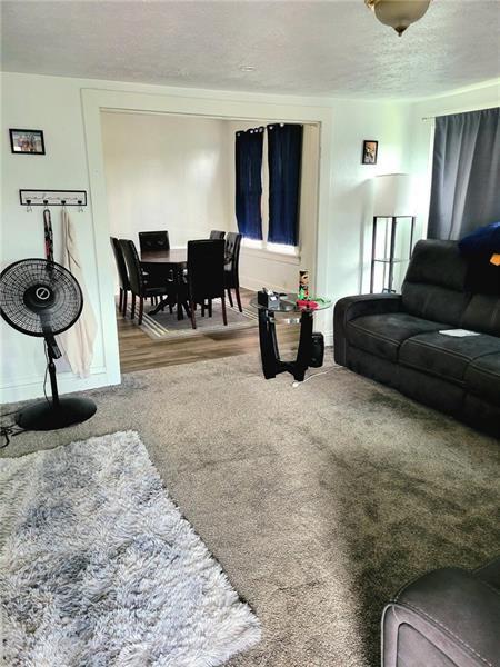 carpeted living room featuring a textured ceiling