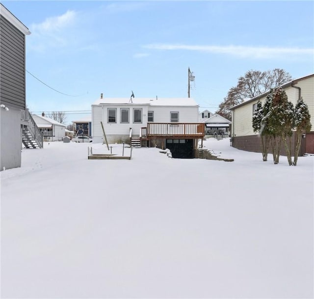 snow covered back of property featuring a wooden deck