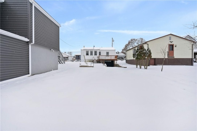 yard covered in snow featuring a wooden deck