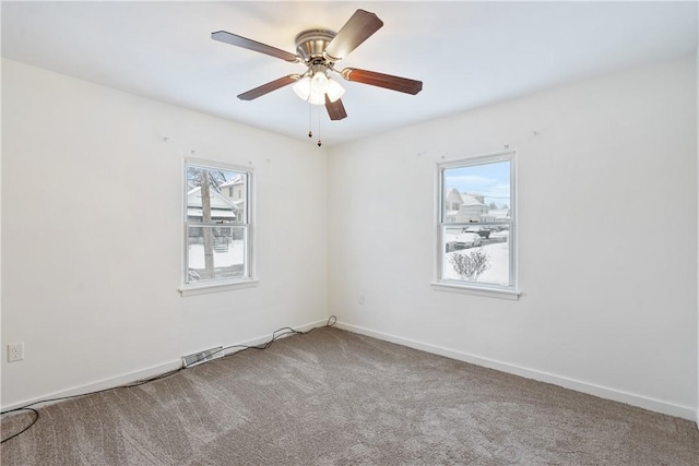 empty room featuring ceiling fan, plenty of natural light, and carpet floors