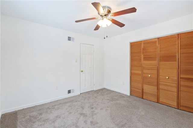 unfurnished bedroom with ceiling fan, light colored carpet, and a closet