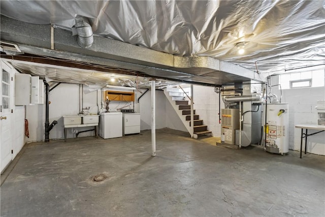 basement featuring sink, washer and clothes dryer, and water heater