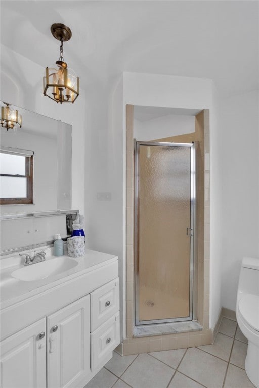 bathroom featuring toilet, vanity, tile patterned floors, an enclosed shower, and a chandelier