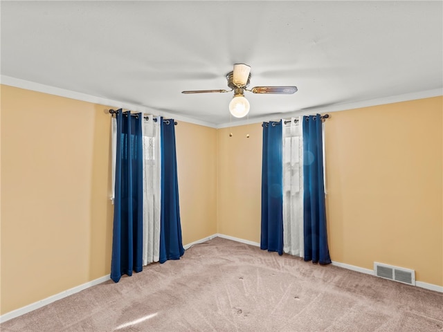 spare room with ceiling fan, crown molding, and carpet flooring