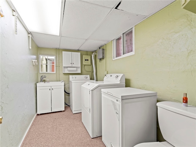 clothes washing area with washer and dryer, light colored carpet, and sink