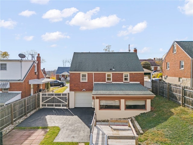 rear view of house with a garage and a yard