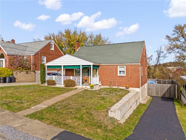 bungalow-style house with a front yard and covered porch