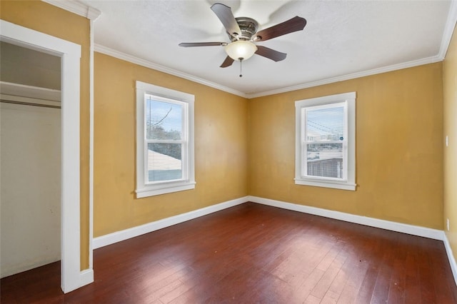 unfurnished bedroom with ceiling fan, dark hardwood / wood-style flooring, multiple windows, and ornamental molding