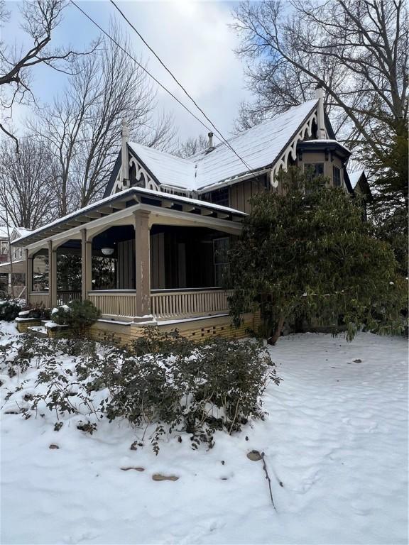 view of snow covered exterior with covered porch