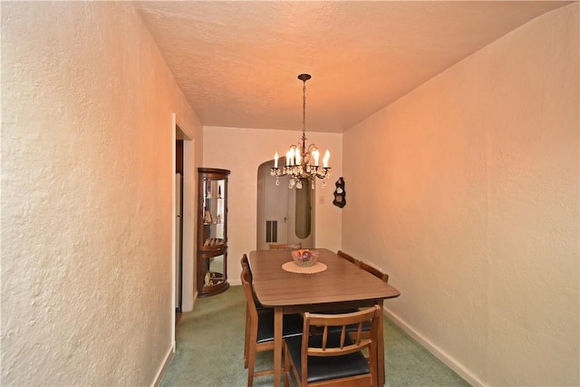 carpeted dining space featuring a chandelier