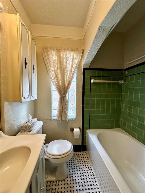 full bathroom featuring toilet, vanity, and washtub / shower combination