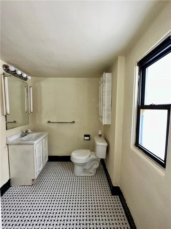 bathroom featuring toilet, vanity, and plenty of natural light