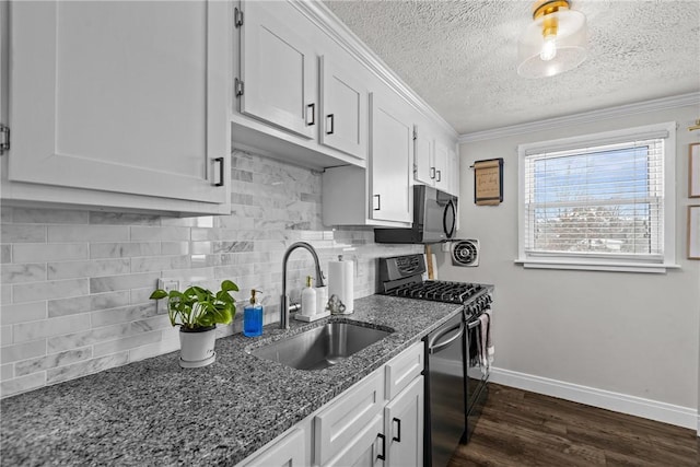 kitchen featuring backsplash, sink, white cabinetry, dark stone counters, and gas range