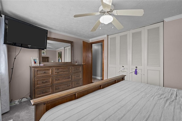 carpeted bedroom with ceiling fan, a closet, crown molding, and a textured ceiling