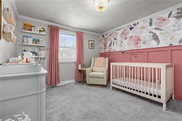 carpeted bedroom with a textured ceiling, crown molding, and a nursery area