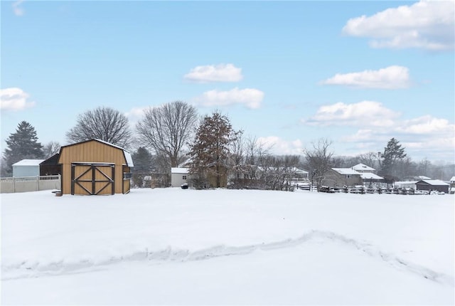 yard layered in snow featuring a storage shed