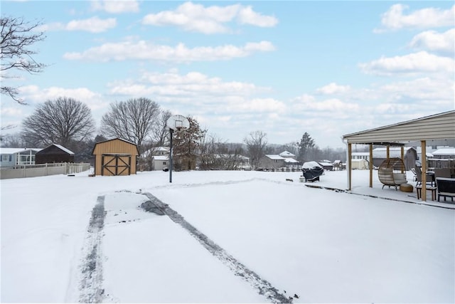 snowy yard with a shed