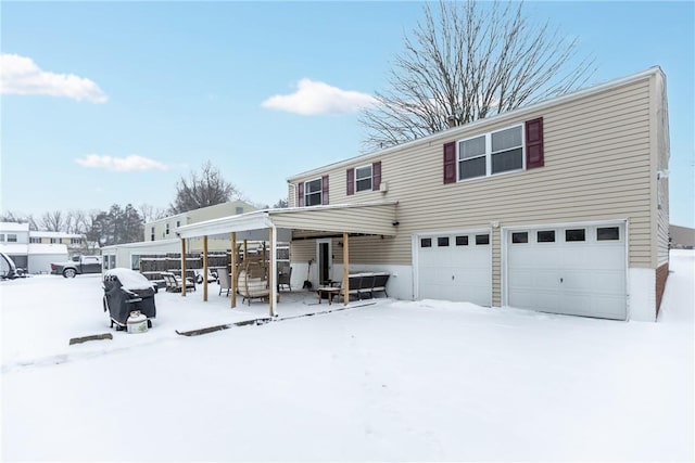 snow covered house featuring a garage