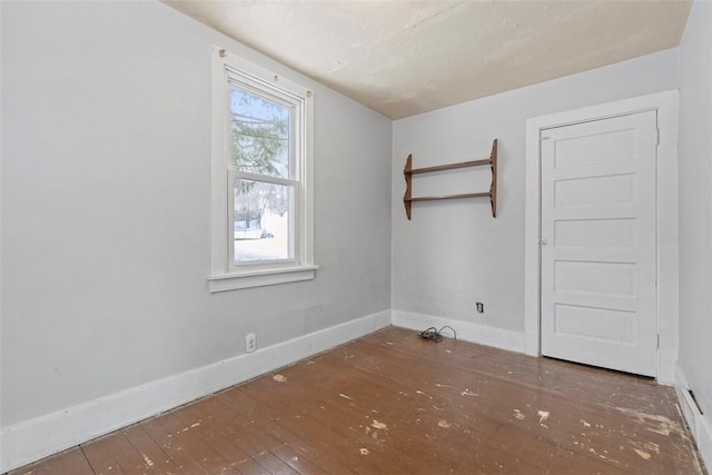 empty room featuring dark wood-type flooring and a wealth of natural light