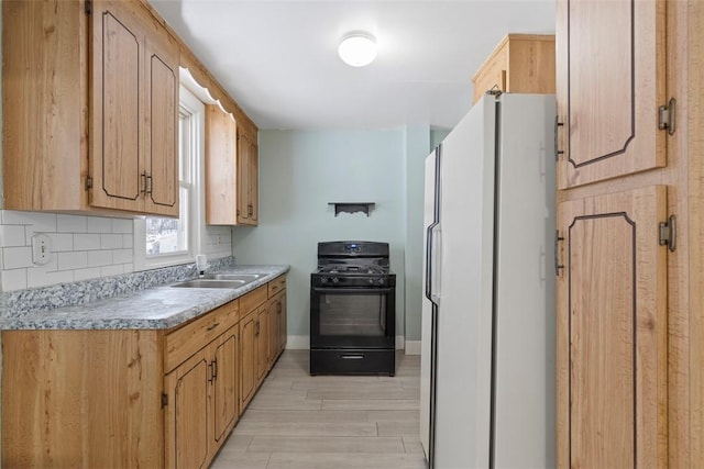 kitchen with white fridge, light hardwood / wood-style floors, decorative backsplash, sink, and black gas range oven