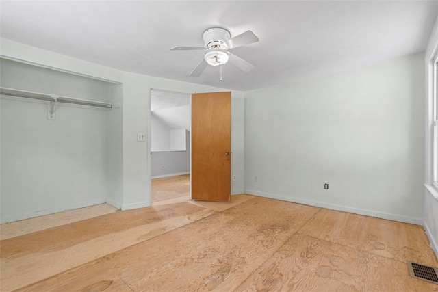 unfurnished bedroom with ceiling fan and a closet