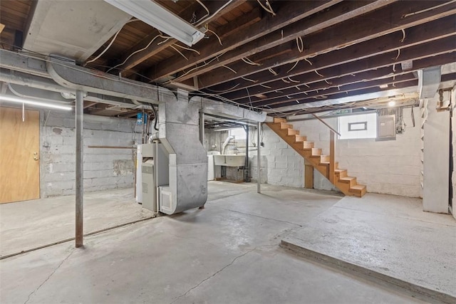 basement with heating unit, sink, and electric panel