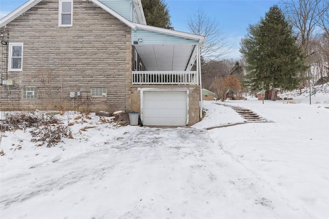 view of snowy exterior featuring a garage