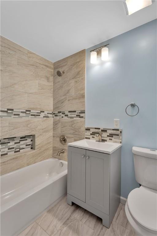 full bathroom featuring toilet, tiled shower / bath, backsplash, and vanity