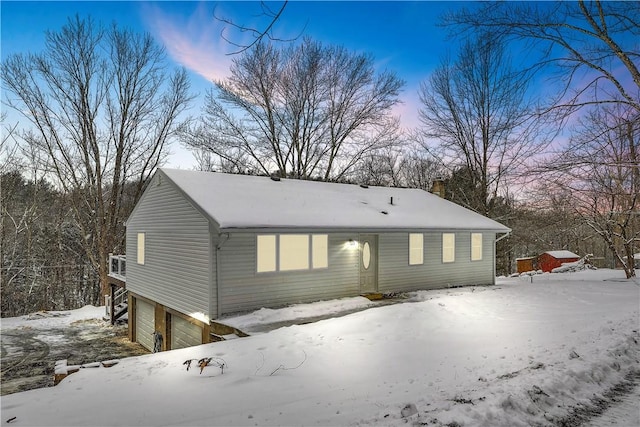 snow covered property with a garage