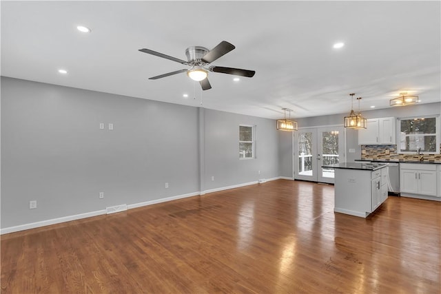 kitchen featuring ceiling fan, backsplash, french doors, hanging light fixtures, and white cabinets