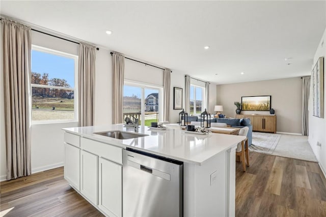 kitchen featuring white cabinetry, dishwasher, sink, a kitchen island with sink, and light hardwood / wood-style floors