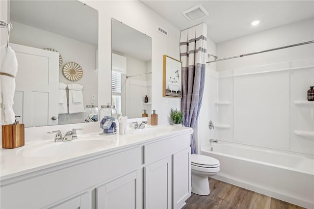 full bathroom with wood-type flooring, toilet, shower / tub combo with curtain, and vanity