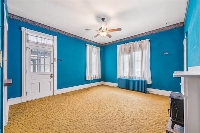 interior space with radiator, ceiling fan, and carpet flooring