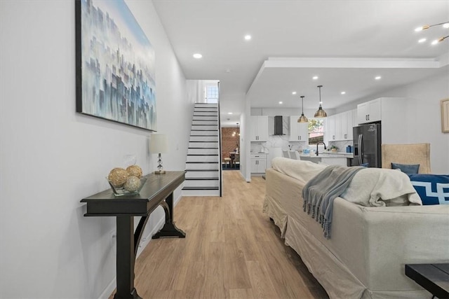 living room featuring light wood-type flooring and sink