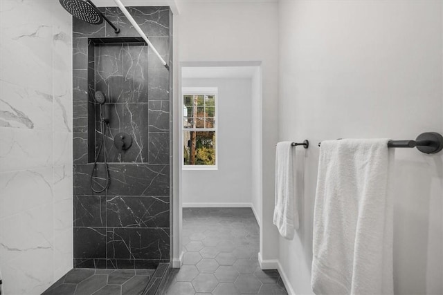 bathroom featuring tile patterned flooring and a tile shower