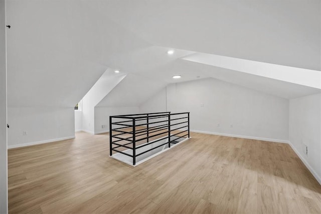 bonus room with lofted ceiling and light hardwood / wood-style floors