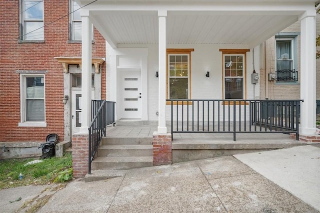 view of exterior entry featuring covered porch