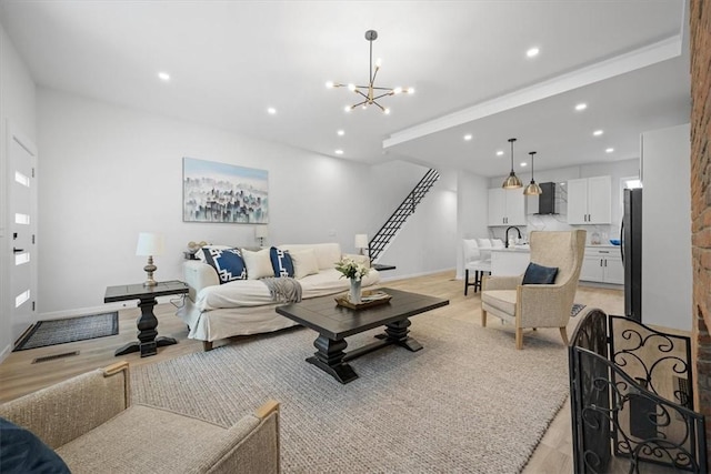 living room with sink, light hardwood / wood-style floors, and a notable chandelier